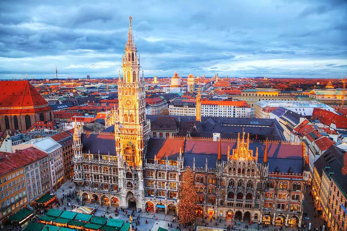 Vista aérea de la histórica plaza Marienplatz de Múnich con la torre iluminada del Ayuntamiento Nuevo neogótico y el mercado navideño