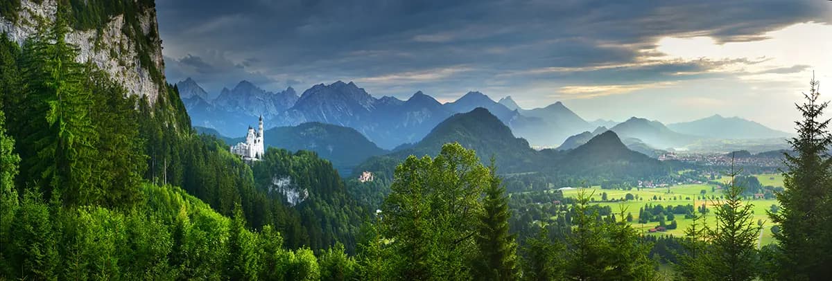 Neuschwanstein Castle nestled in the Bavarian Alps with dramatic mountain peaks in the background